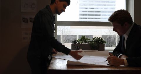 Architects Collaborating on Blueprint at Office Desk - Download Free Stock Images Pikwizard.com