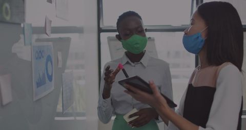 Businesswomen Collaborating on Financial Dashboard While Masked