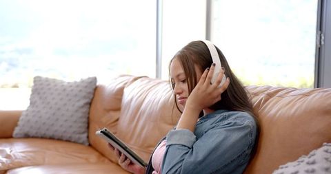 Teen Girl Listening to Music on Tablet with Headphones