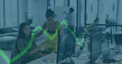 Team Collaborating at Monitor with Green Financial Graph Overlay in Modern Office