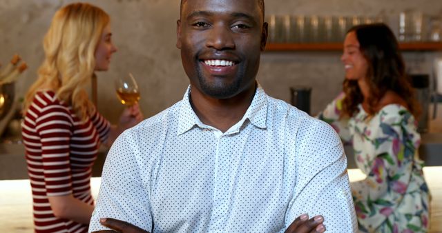 Confident Man Smiling with Friends in Background at Cafe - Download Free Stock Images Pikwizard.com