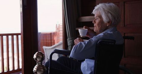 Senior Woman in Wheelchair Enjoying Coffee Thoughtfully
