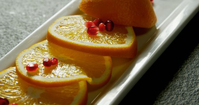 Top view of fresh orange slices and pomegranate seeds on a white plate - Download Free Stock Images Pikwizard.com