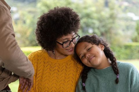 Caregiver enjoying cozy park bench moment with child, family bonding and warmth