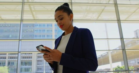 Professional Pastel Executive Uses Mobile Phone in Modern Office Lobby