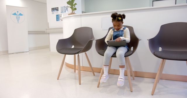 Young Girl Using Tablet While Waiting in Medical Clinic - Download Free Stock Images Pikwizard.com