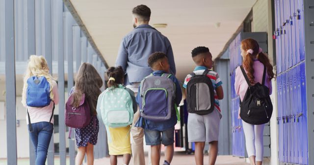 Teacher guiding diverse students through school hallway - Download Free Stock Images Pikwizard.com