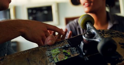 Hands-on skateboard maintenance discussion indoors