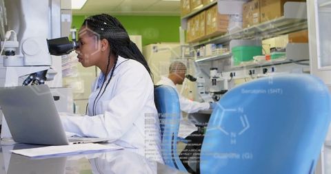 Scientist conducting research with microscope in modern laboratory