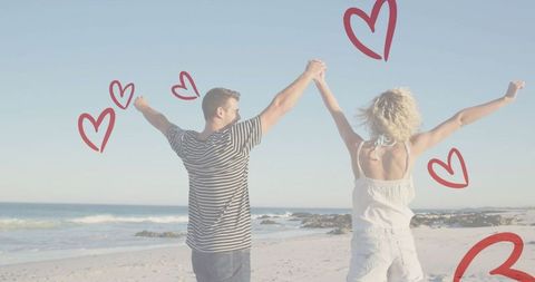 Joyful Couple Holding Hands on Sunny Beach with Heart Doodles