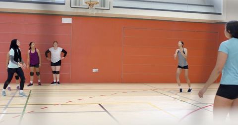 Diverse women practicing basketball and volleyball in indoor gym wearing sports hijab