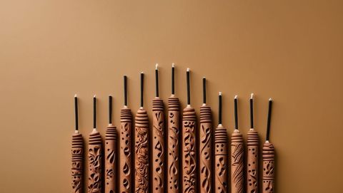 Hand-carved sandalwood decorative candles with intricate patterns on tabletop