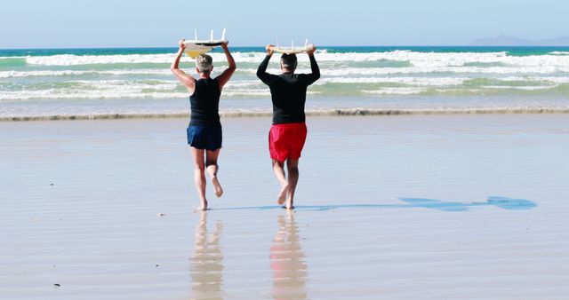 Two Surfers Carrying Surfboards on Sunny Beach - Download Free Stock Images Pikwizard.com