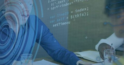 Leaning professional in blue shirt reaching across table with projected code and documents