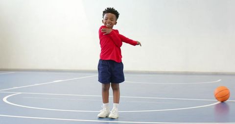 Energetic Boy Stretching on Indoor Basketball Court