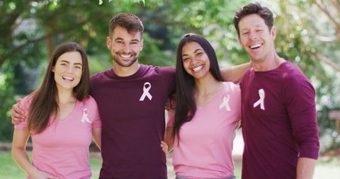 Diverse Group Embracing for Breast Cancer Awareness in Park