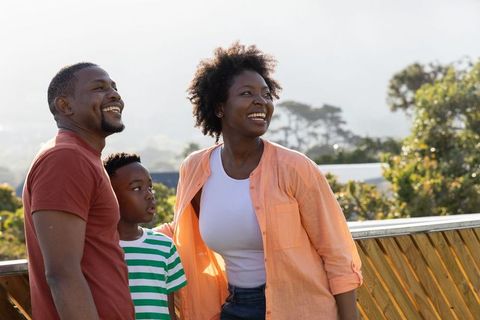 African american family enjoying balcony with parents and son overlooking green hills