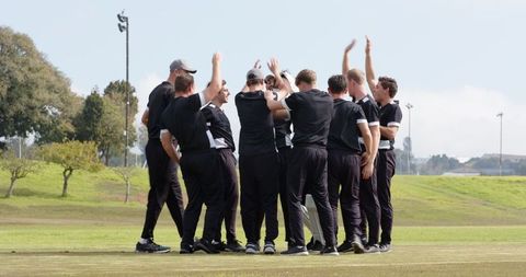 Sports Team Celebrating Victory with Energetic Huddle on Field