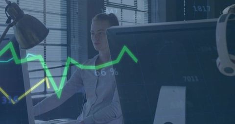 Woman monitoring financial market charts on large desktop monitors, focused analyst at desk