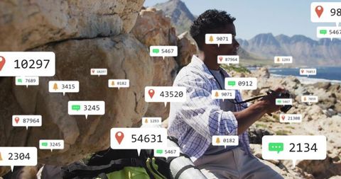 Coastal angler fishing on rocky shore with digital location pins and notification overlays