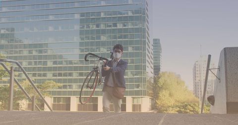 Man carrying bicycle up city stairs for sustainable commute