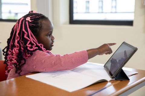 Young African American Girl Learning with Tablet in Classroom