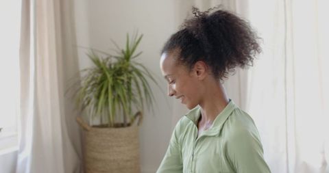 Young Woman Stretching by Window for Relaxation and Wellness