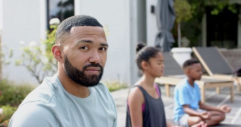 Father Practicing Meditation with His Children Outdoors