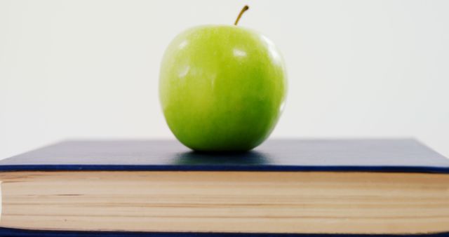 Fresh Green Apple on Top of a Closed Book - Download Free Stock Photos Pikwizard.com