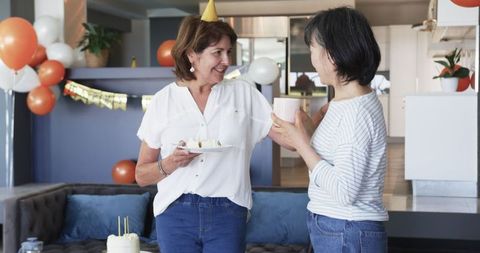 Senior Friends Celebrating Birthday with Cake and Coffee in Living Room