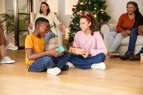 Children Exchanging Christmas Gifts with Family in Cheerful Setting