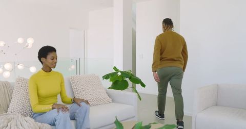 Couple in contemporary living room with man walking away