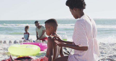 African American Family Relaxing on Sunny Beach Day