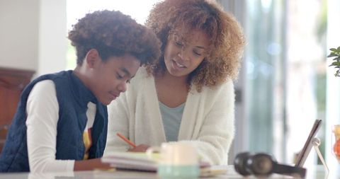 Loving Mother Helping Her Son with Homework in Cozy Kitchen