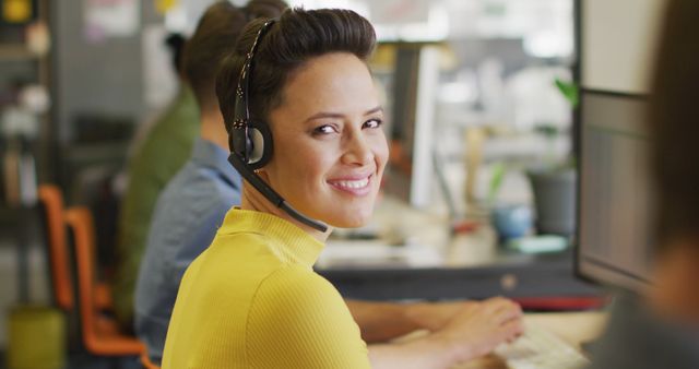 Portrait of happy caucasian businesswoman using phone headset and looking at camera at office. Work at a modern office.