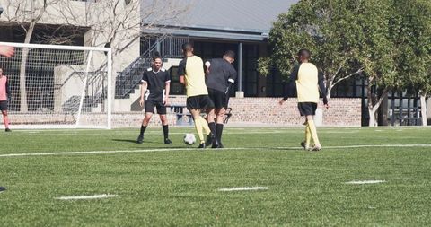 Soccer players competing intensely on turf field during day