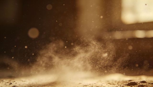 Backlit dust motes rising over old wooden floor with warm sunlight bokeh and amber glow