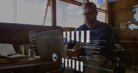 Mature developer working remotely in rustic cabin projecting holographic code, charts, world map