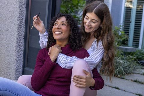Joyful female bonding with dropper bottle in outdoor setting