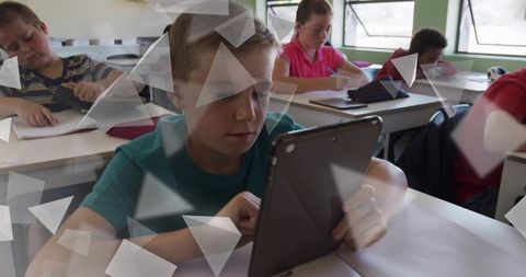 Elementary Student Using Tablet in Classroom Learning Digital Skills and Focused Study with Notebook