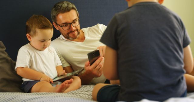 Father and Sons Bonding Using Digital Tablets and Smartphones - Download Free Stock Images Pikwizard.com