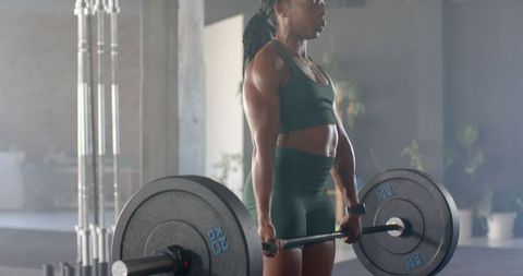 Female Athlete Performing Deadlift in Gym for Strength Training