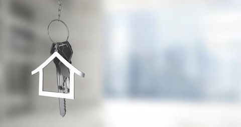 Hanging house keyring with keys and metal home charm in modern interior