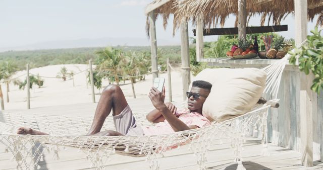 Man Relaxing in Hammock Reading Smartphone at Tropical Beach Resort - Download Free Stock Images Pikwizard.com