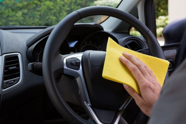 Man Cleaning Car Steering Wheel with Yellow Cloth - Download Free Stock Photos Pikwizard.com
