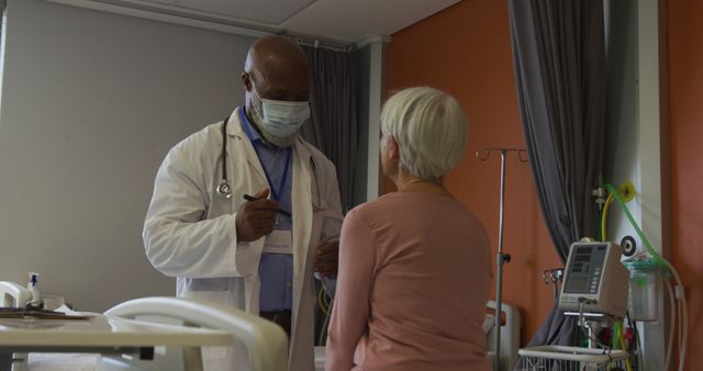 African american male doctor examining senior caucasian female patient at hospital. Medicine, healthcare, lifestyle and hospital concept.