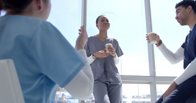 Medical Professionals Taking Coffee Break and Chatting by Window - Download Free Stock Images Pikwizard.com