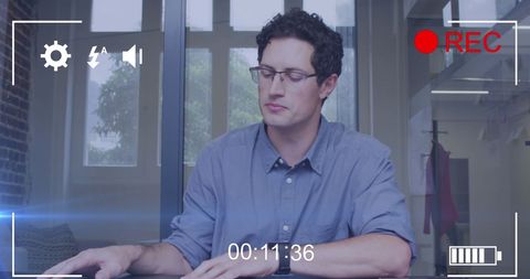 Professional with Glasses Focused on Laptop Work in Office