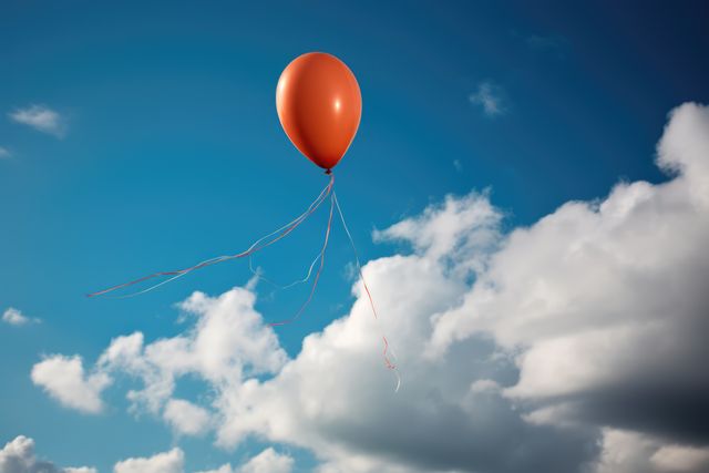 Orange party balloon floating in cloudy blue sky, copy space, created using generative ai technology. Freedom, celebration and independence, digitally generated image.