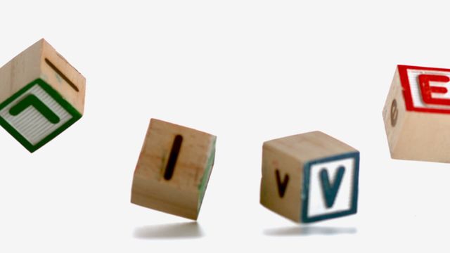 Wooden alphabet blocks spelling the word 'love' are caught falling mid-air on a white background, creating a dynamic and engaging scene. This is ideal for illustrating themes of playfulness, childhood education, or affection. Especially useful for designs related to early learning materials, family-oriented advertisements, or creative projects concerning love and relationships.